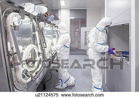 Stock Photography - Technicians working in sealed, sterile isolator units in a laboratory that manufactures human tissues for implant. Such tissues include bone and skin grafts.. Fotosearch