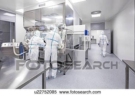 Stock Photography - Technicians working in sealed, sterile isolator units in a laboratory that manufactures human tissues for implant. Such tissues include bone and skin grafts.. Fotosearch