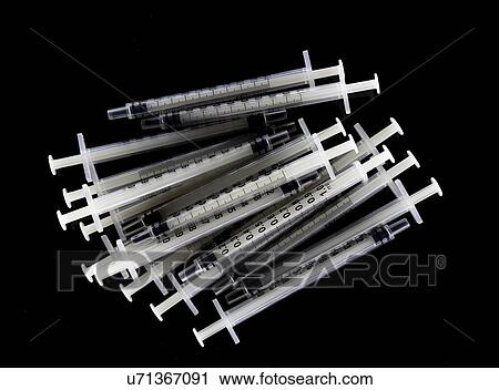 Stock Image - Tuberculin syringes on black background.. Fotosearch