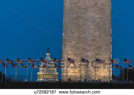 Stock Photo - US Flags with cropped view of US Capitol and Washington Monument surrounded by visitors to Washington, D. C. . Fotosearch