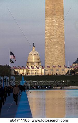 Stock Photography - US Flags with cropped view of US Capitol and Washington Monument surrounded by visitors to Washington, D. C. . Fotosearch