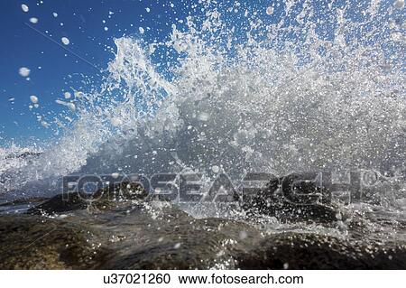 Stock Image - Waves breaking against rocks.. Fotosearch