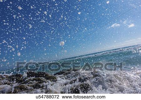 Waves breaking against rocks. View Large Photo Image Stock Image - Waves breaking against rocks.. Fotosearch