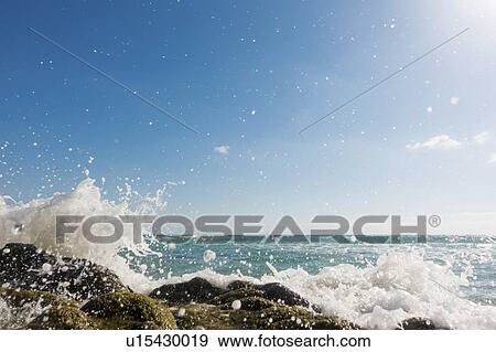 Stock Photo - Waves breaking against rocks.. Fotosearch