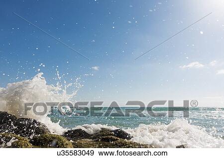 Waves breaking against rocks. View Large Photo Image Stock Photo - Waves breaking against rocks.. Fotosearch
