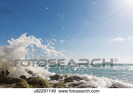 Waves breaking against rocks. View Large Photo Image Stock Photo - Waves breaking against rocks.. Fotosearch