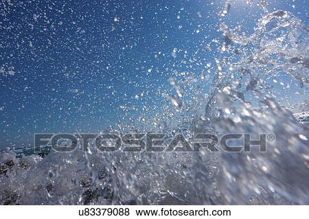 Stock Photo - Waves breaking against rocks.. Fotosearch
