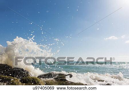 Stock Photo - Waves breaking against rocks.. Fotosearch