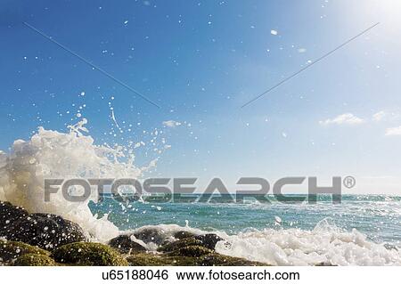 Waves breaking against rocks. View Large Photo Image Stock Photograph - Waves breaking against rocks.. Fotosearch