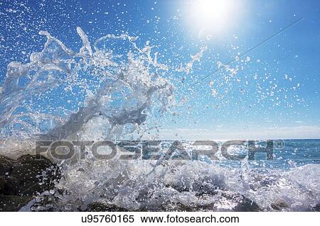 Stock Photography - Waves breaking against rocks.. Fotosearch