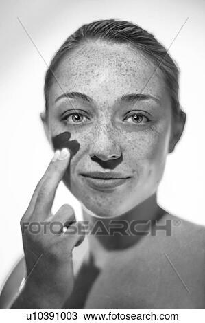 Woman applying sunscreen to her cheek. View Large Photo Image Stock Image - Woman applying sunscreen to her cheek.. Fotosearch