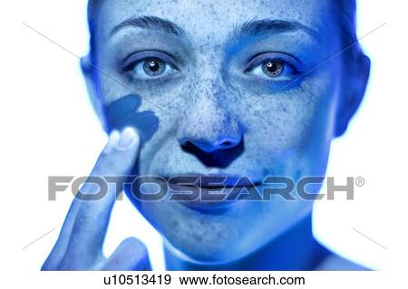 Woman applying sunscreen to her cheek. View Large Photo Image Stock Photo - Woman applying sunscreen to her cheek.. Fotosearch