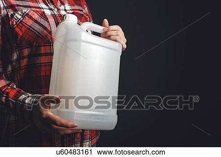 Stock Image - Woman holding plastic canister.. Fotosearch