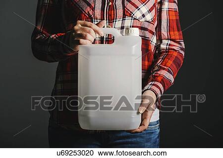 Stock Image - Woman holding plastic canister.. Fotosearch