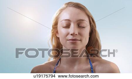 Picture - Woman in sunlight with eyes closed.. Fotosearch