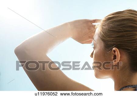 Woman shielding her eyes from the sun. View Large Photo Image Stock Image - Woman shielding her eyes from the sun.. Fotosearch