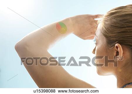 Stock Photo - Woman shielding her eyes from the sun.. Fotosearch