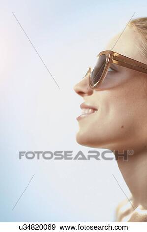 Woman wearing sunglasses, smiling. View Large Photo Image Stock Photo - Woman wearing sunglasses, smiling.. Fotosearch