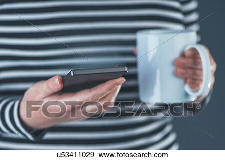 Woman with smartphone and mug. View Large Photo Image Stock Photo - Woman with smartphone and mug.. Fotosearch