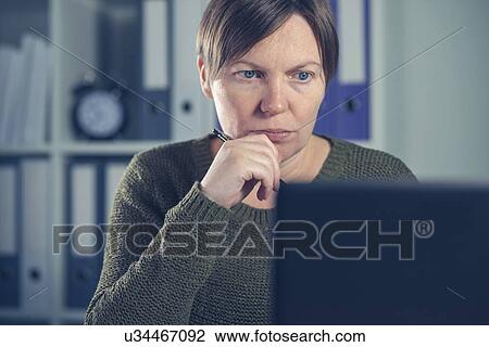Stock Image - Woman working at desk.. Fotosearch