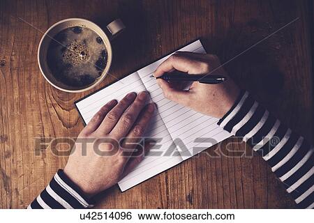 Stock Photograph - Woman writing in notebook.. Fotosearch