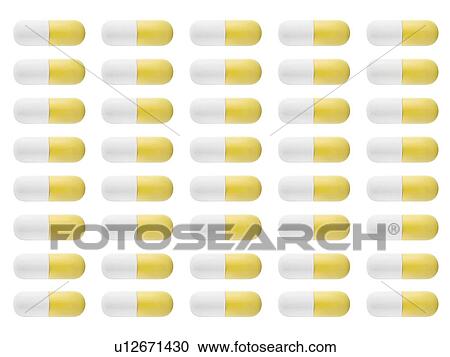 Stock Image - Yellow and white capsules, studio shot.. Fotosearch
