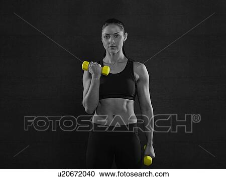 Young woman holding yellow hand weights, portrait. View Large Photo Image Stock Image - Young woman holding yellow hand weights, portrait.. Fotosearch