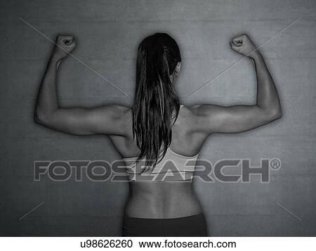 Young woman in sports top flexing muscles, rear view. View Large Photo Image Stock Image - Young woman in sports top flexing muscles, rear view.. Fotosearch