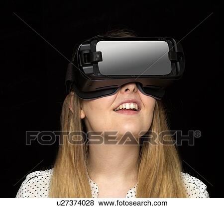 Young woman wearing virtual reality headset, studio shot. View Large Photo Image Stock Photo - Young woman wearing virtual reality headset, studio shot.. Fotosearch
