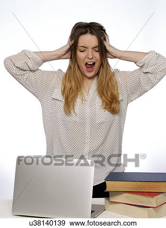 Stock Photo - Young woman with hands in hair and laptop.. Fotosearch