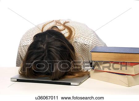 Stock Image - Young woman with head on laptop.. Fotosearch
