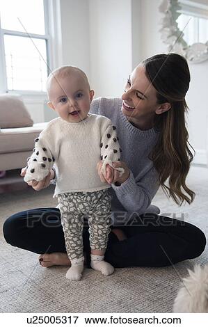Baby girl (18-23 months) making first steps with help of mother View Large Photo Image Stock Photo - Baby girl (18-23 months) making first steps with help of mother. Fotosearch