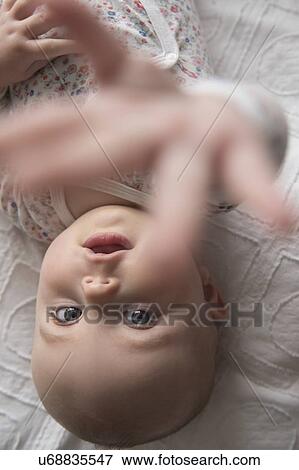 Baby girl (18-23 months) reaching for camera View Large Photo Image Stock Photo - Baby girl (18-23 months) reaching for camera. Fotosearch