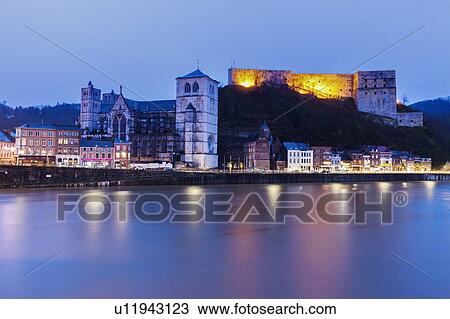 Stock Image - Belgium, Wallonia, Huy, Huy Citadel and Notre Dame Church at night. Fotosearch