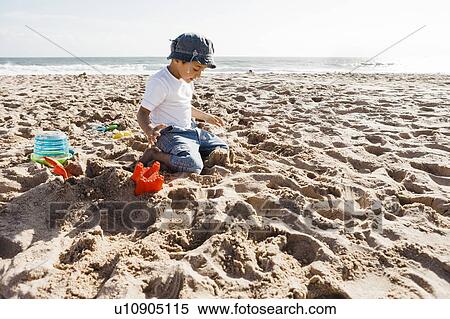 Stock Photography - Boy (4-5) playing on beach. Fotosearch
