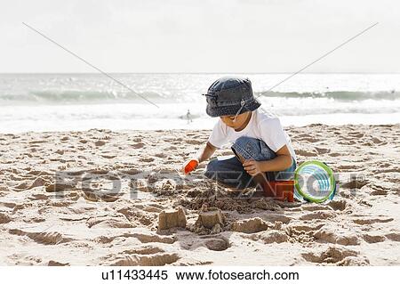 Stock Photography - Boy (4-5) playing on beach. Fotosearch