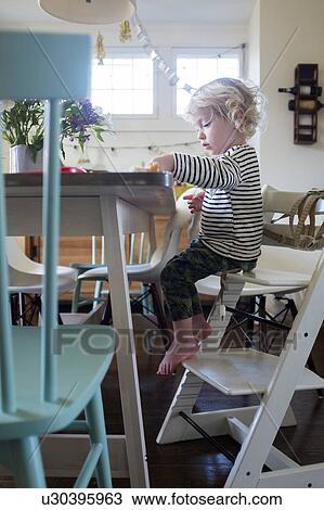Stock Image - Boy at table on step ladder. Fotosearch