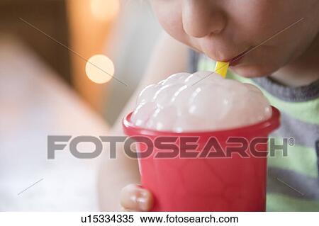 Stock Photography - Boy blowing bubbles in drink. Fotosearch