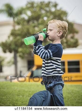 Picture - Boy drinking from bottle. Fotosearch