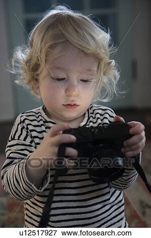 Stock Photo - Boy holding camera. Fotosearch