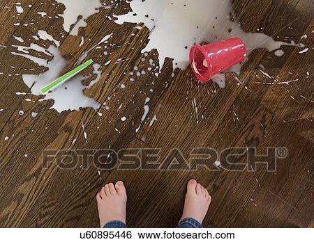 Stock Photograph - Boy's feet by spilt milkshake. Fotosearch