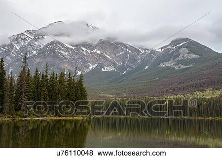 Stock Photo - Canada, Alberta, Jasper, Mountains reflecting in Pyramid Lake. Fotosearch