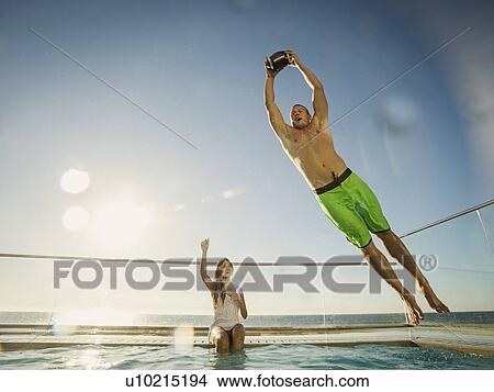 Couple playing football in swimming pool View Large Photo Image Picture - Couple playing football in swimming pool. Fotosearch