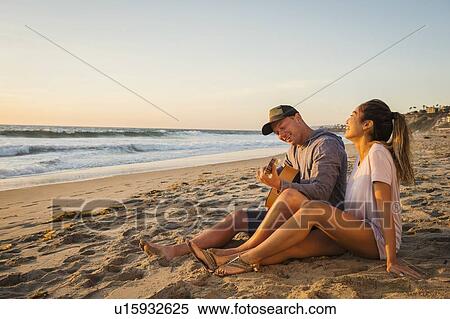 Couple sitting on beach View Large Photo Image Stock Photography - Couple sitting on beach. Fotosearch