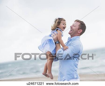 Stock Image - Father holding daughter. Fotosearch