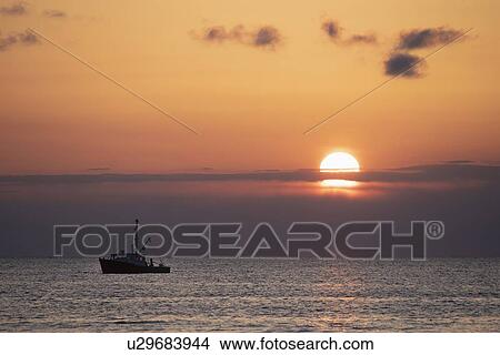 Picture - Fishing boat at sunset. Fotosearch