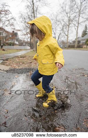 Stock Photo - Girl (2-3) playing in puddle. Fotosearch