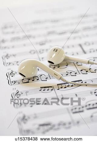Stock Photo - In-ear headphones on sheet music. Fotosearch