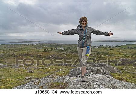 Picture - Ireland, Galway County, Woman hiking above Galway Bay. Fotosearch