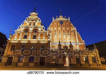 Stock Image - Latvia, Riga, Illuminated House of the Blackheads at night. Fotosearch